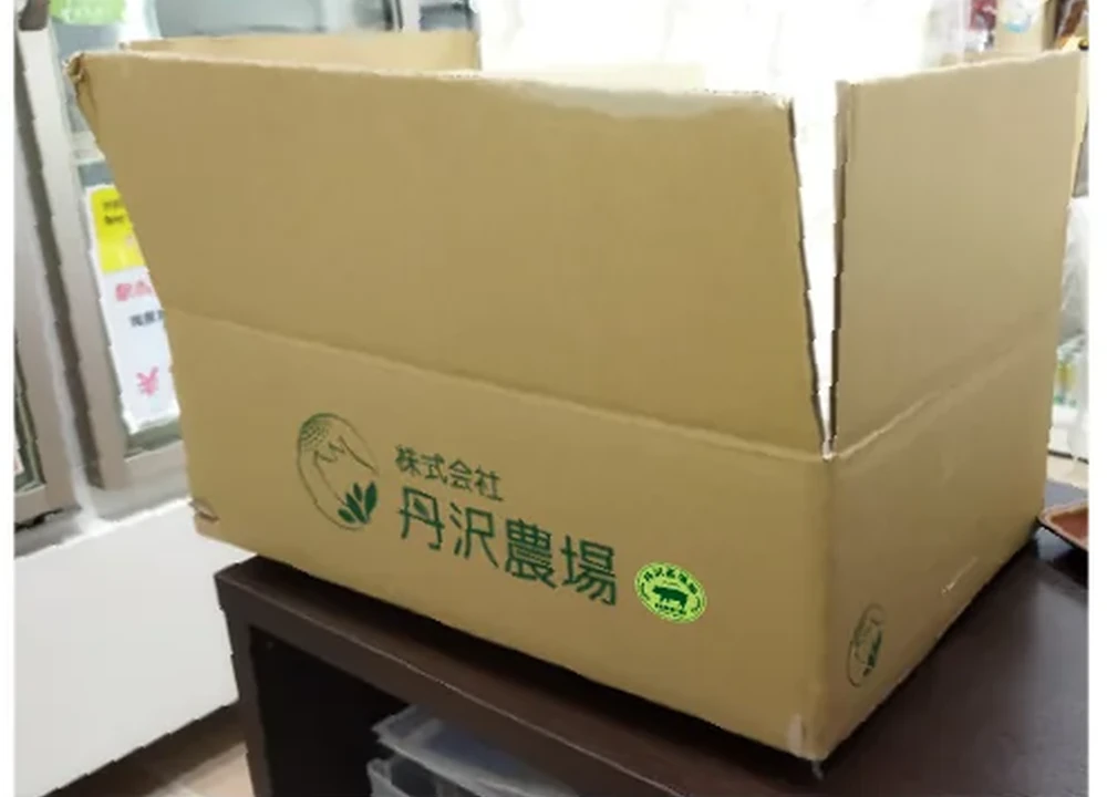 段ボールに丹沢高原豚ブランドマークを配置した使用イメージ